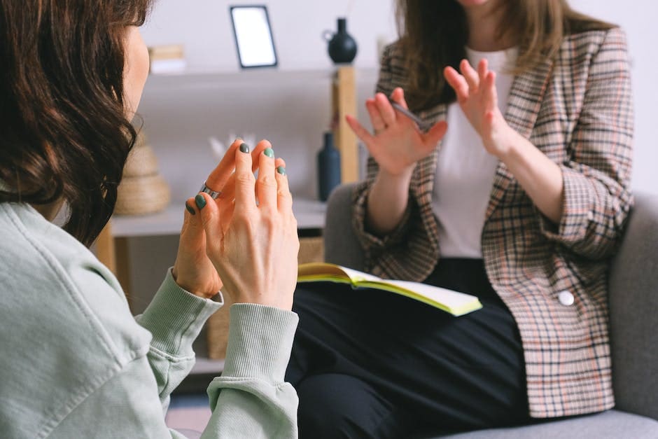 A small group of people engaged in an animated discussion during an indoor workshop, with one participant gesturing expressively while others listen attentively.